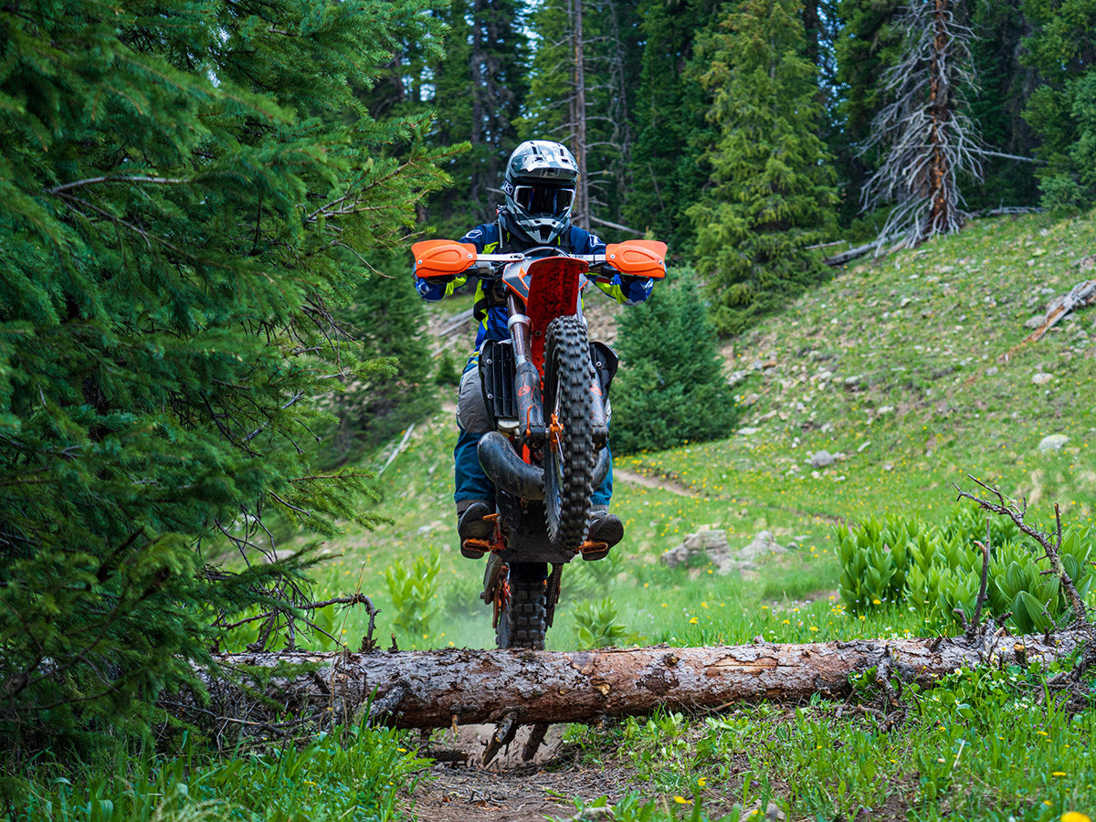Motorcyclist riding over downed tree